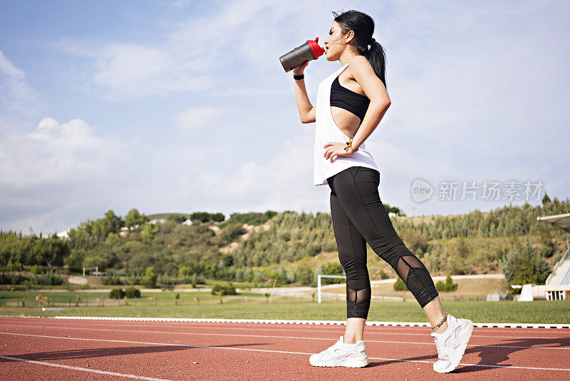 年轻女子运动员在运动训练后喝水