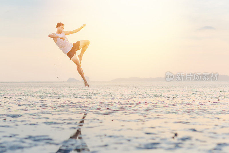 年轻的亚洲男子在日落海滩做瑜伽运动