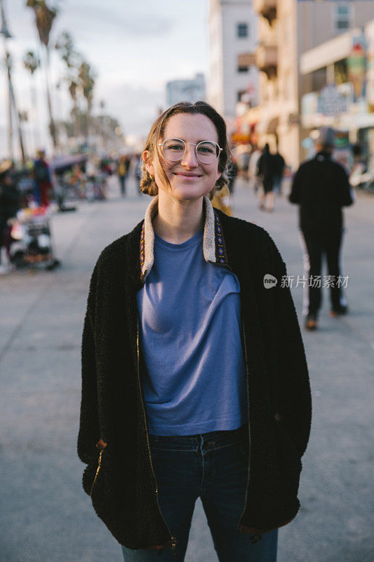 海滩上穿着黑夹克的微笑女人