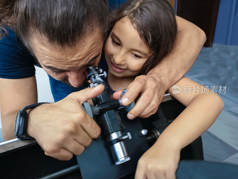 父亲和女儿用光学仪器学习科学