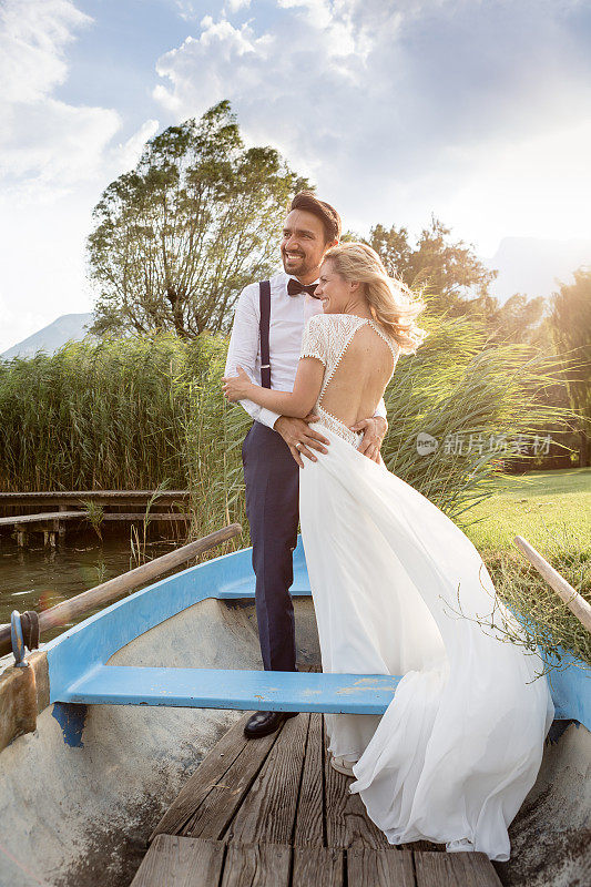 快乐的新婚夫妇在湖上划着小船