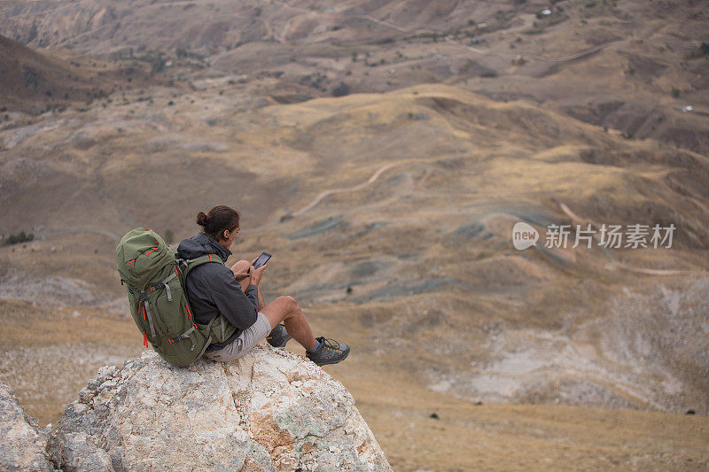 登山者在山顶使用智能手机