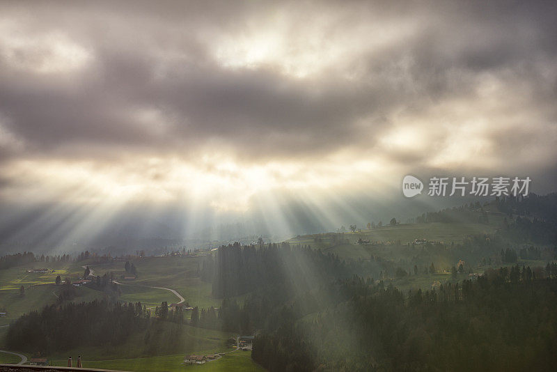 阳光透过高山的云层照耀着大地