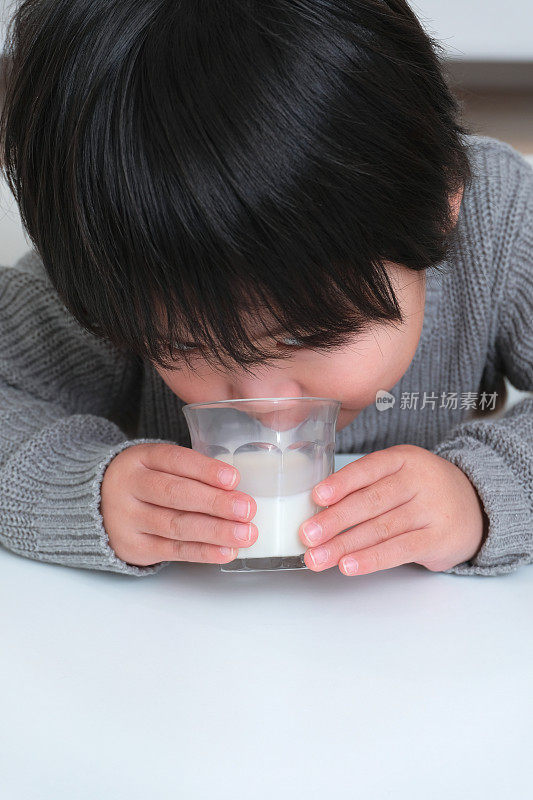 婴儿喝一杯牛奶的特写
