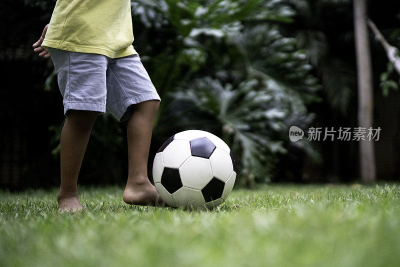 小男孩在后院踢足球