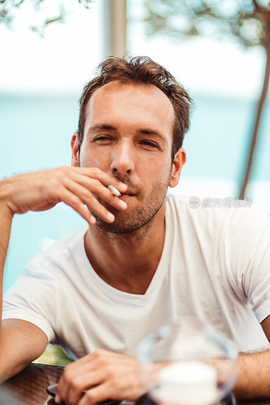 在咖啡馆抽烟的孤独男人