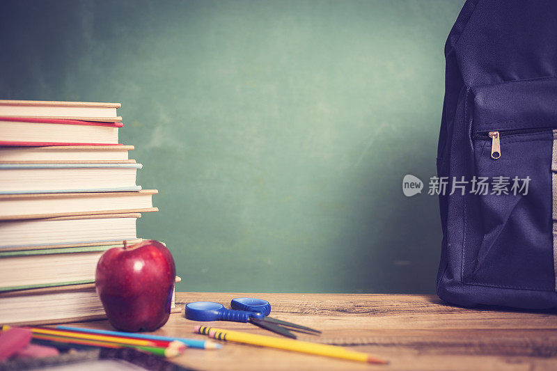红苹果，课桌上放学习用品和黑板。