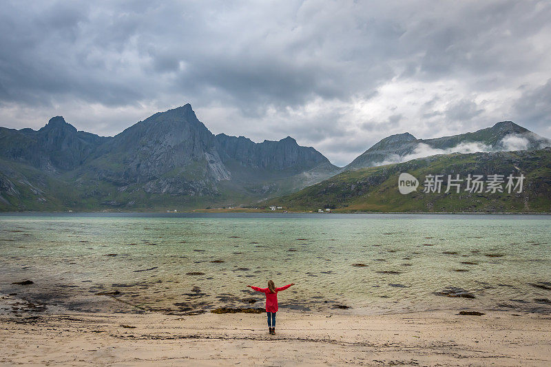 女人看着挪威的山脉和峡湾。