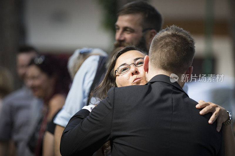 成年女性婚礼嘉宾在婚礼上拥抱并祝贺新郎