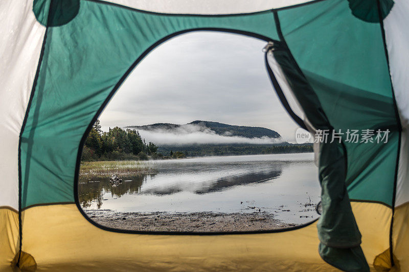 POV来自秋天露营时在湖边的帐篷里休息