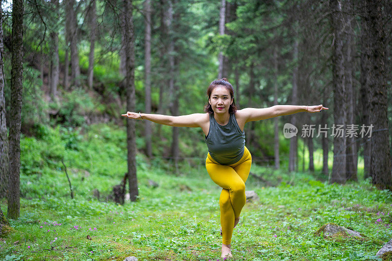 年轻的亚洲女人在森林里练习瑜伽