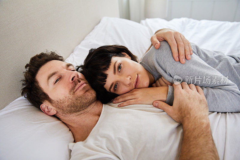 一位年轻女子躺在床上，头靠在丈夫的胸前
