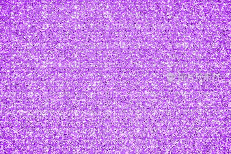 紫色紫罗兰水晶亮纹理背景。闪光的亮灯