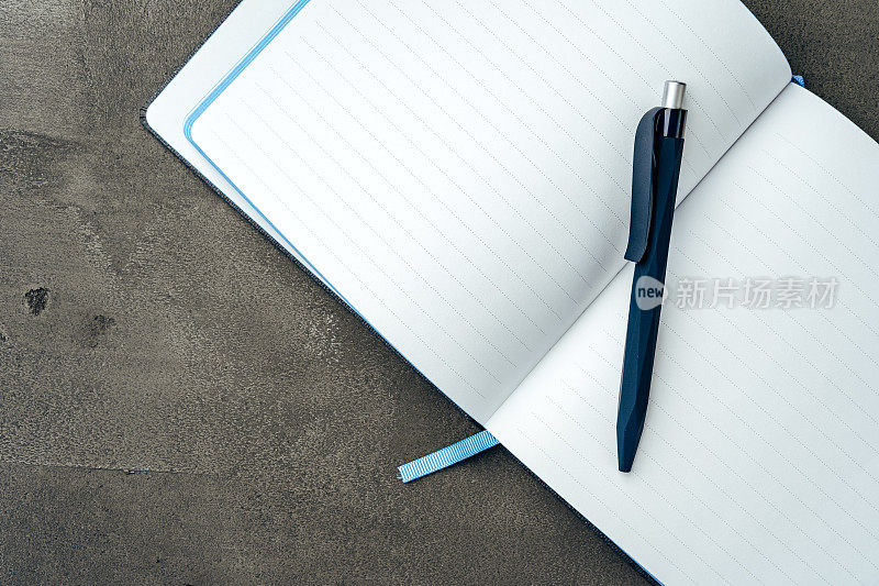 深灰色背景上的男人的日记和钢笔