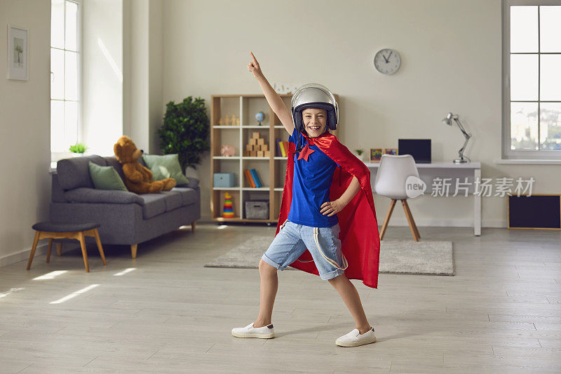 男孩英雄在飞行员服装和头盔扮演超级英雄的角色在家里