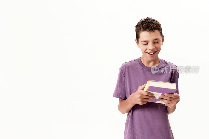 一名患有脑瘫的残疾少年微笑着拿着一本书，在白色背景下摆出孤立的姿势