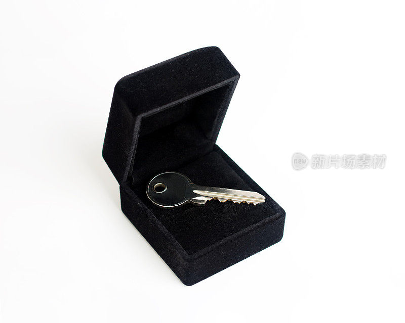 房子钥匙在结婚戒指盒子上白色的背景，礼物房子的概念。