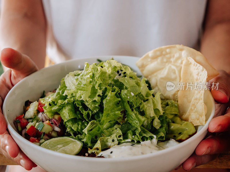 顶视图的女人坐在咖啡馆有新鲜的玉米煎饼碗素食食物