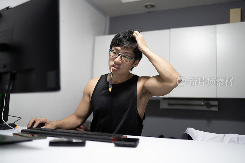 一名亚洲华裔商人在家里用笔记本电脑工作时刷牙累坏了。