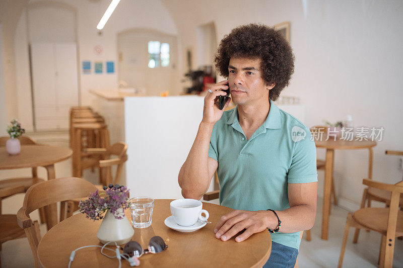 非裔美国混血男子在咖啡馆使用智能手机