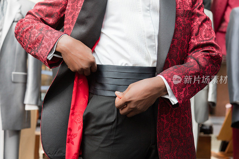 裁缝店黑色男士穿红色燕尾服的手的细节