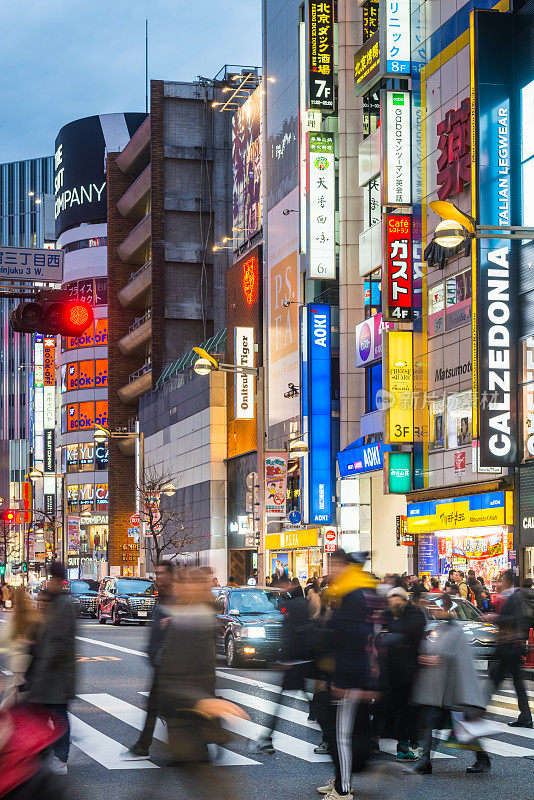 东京的霓虹灯照亮了日本新宿繁忙的购物街