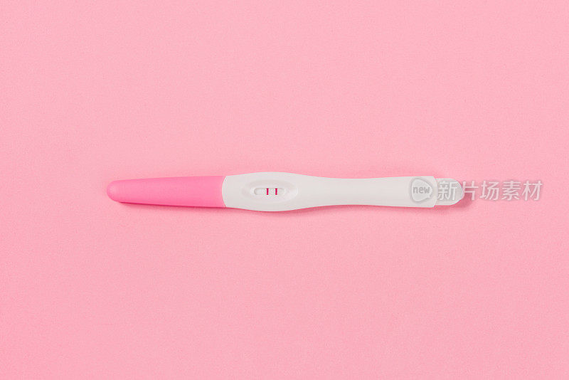 真实阳性妊娠测试。孤立在粉红色背景。