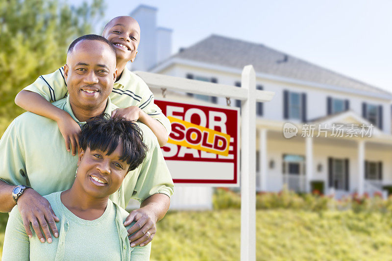 非裔美国人家庭在出售的标志和房子前