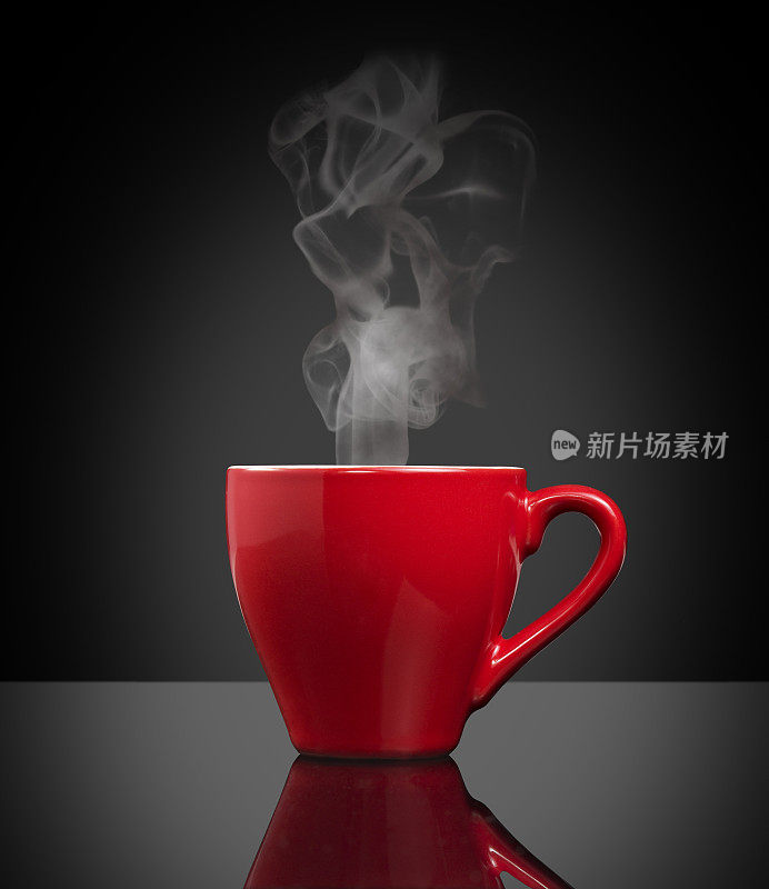 黑色背景下的红杯冒着热气的咖啡