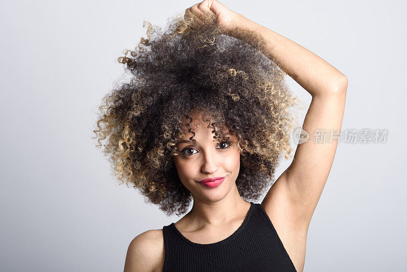 年轻的黑人妇女与非洲式发型微笑