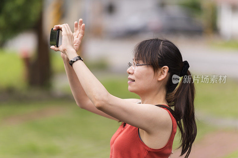 一名亚洲女性正在用手机拍照