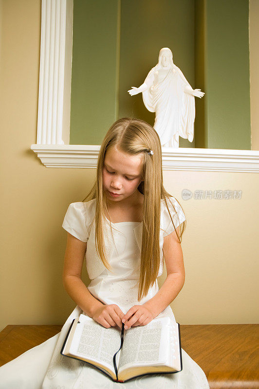 穿白衣的小女孩正在读经文