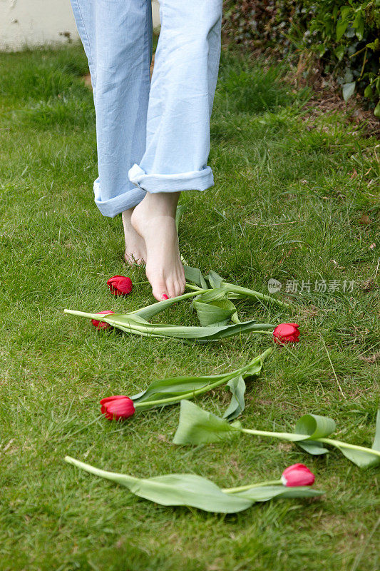 年轻女子踮着脚尖穿过郁金香花丛