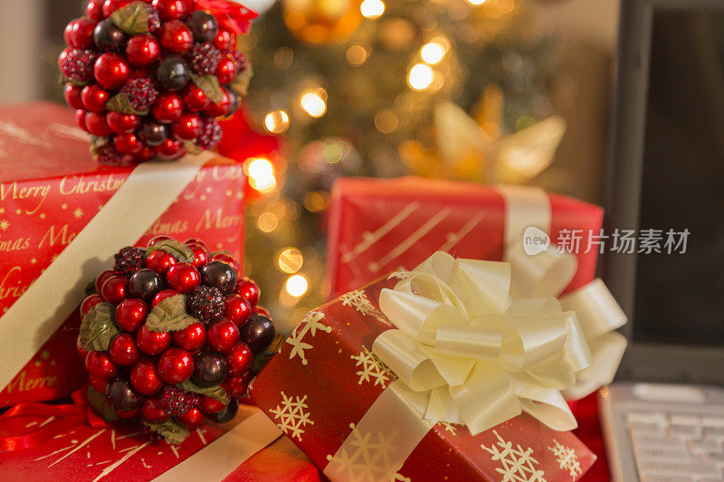 圣诞节:包装精美的节日礼物放在圣诞树前。移动PC
