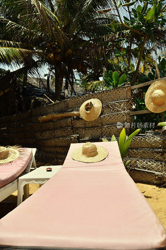 斯里兰卡Hikkaduwa海滩上的沙滩床上戴着草帽