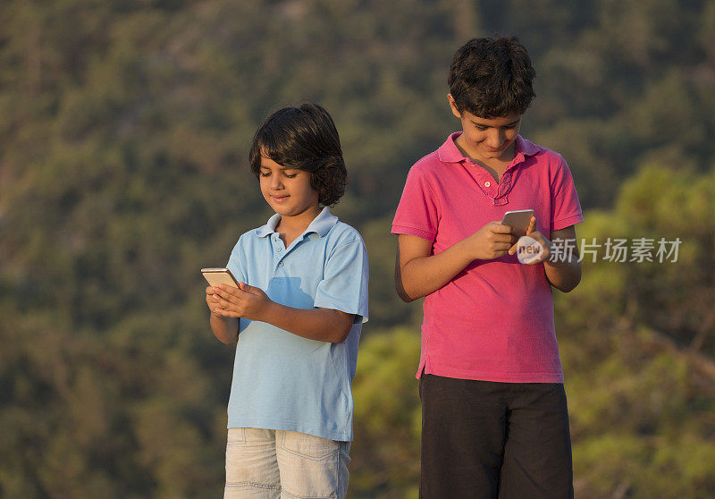 两个男孩在用智能手机