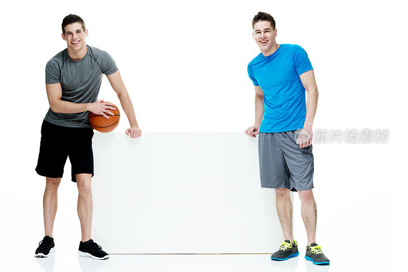两个人抱着篮球，靠在箱子上