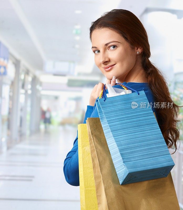 年轻女子拿着包在购物中心