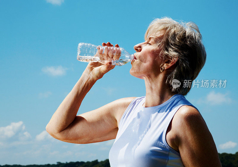 一个在锻炼后喝瓶装水的女人