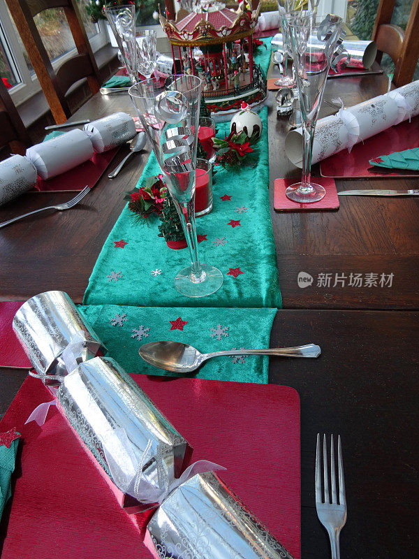 圣诞餐桌上有鞭炮，酒杯，节日装饰