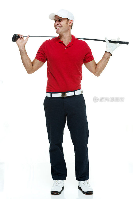 微笑的高尔夫球手站着&拿着高尔夫球杆