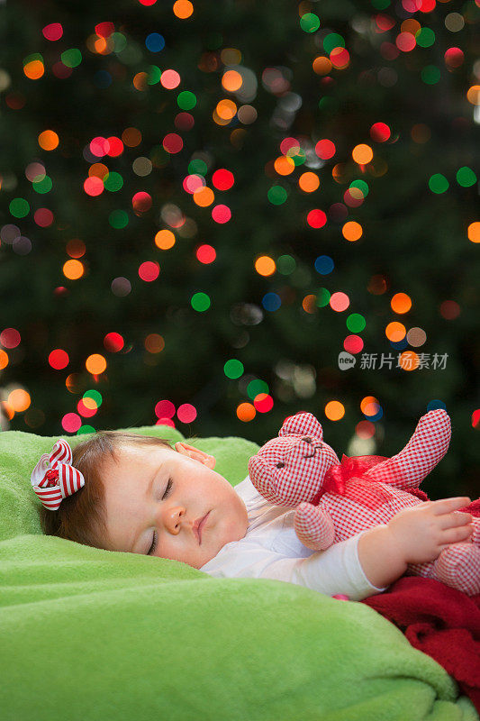 婴儿睡在圣诞树前