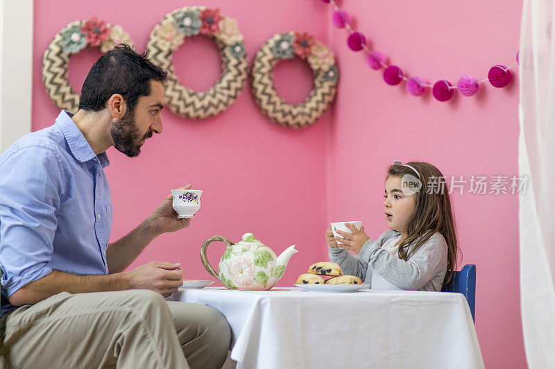 小女孩在茶会上给爸爸讲故事
