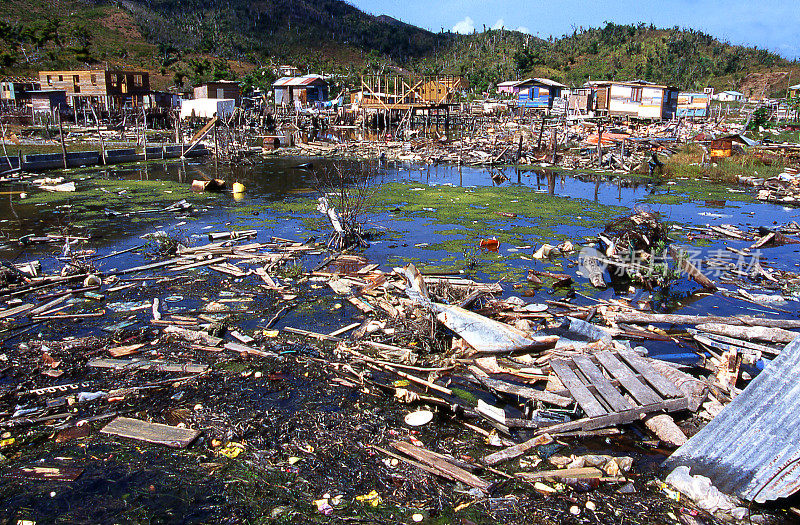 1998年飓风米奇肆虐洪都拉斯瓜纳加湾群岛热带草原湾村，池塘中残留的残骸和破坏