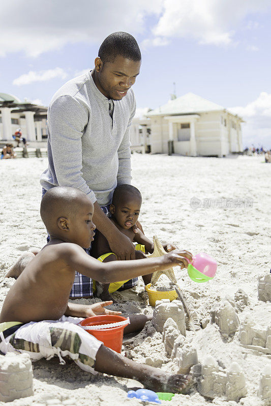 一位非洲父亲和他的儿子们一起建沙堡