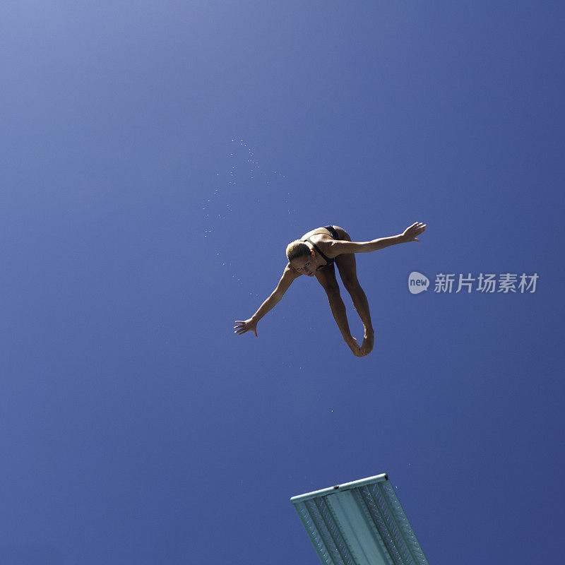 女潜水员在空中，身后是蓝天