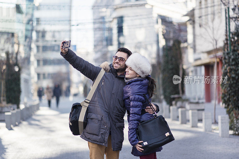 快乐的年轻游客夫妇在街上自拍