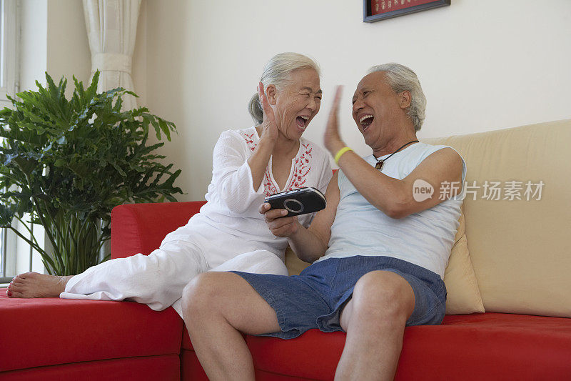 老年夫妇玩掌上游戏机