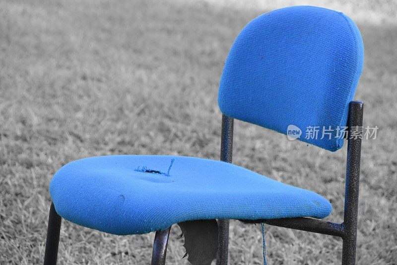 草地上有一把蓝色的椅子