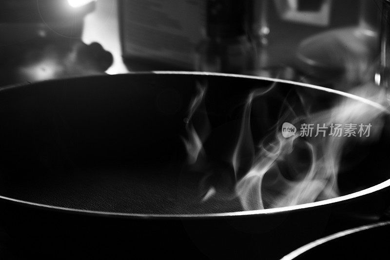 黑白色的烟从平底锅里冒出来